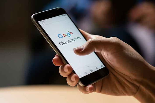 tangan memegang smartphone yang sedang membuka google classroom tangan memegang smartphone yang sedang membuka google classroom